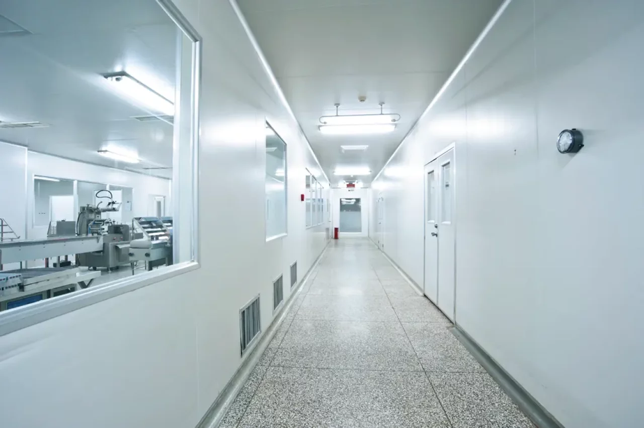 Weißer Korridor eines Labors mit fluoreszierenden Strahlen und Fliesen bei der Crowthorne Group.