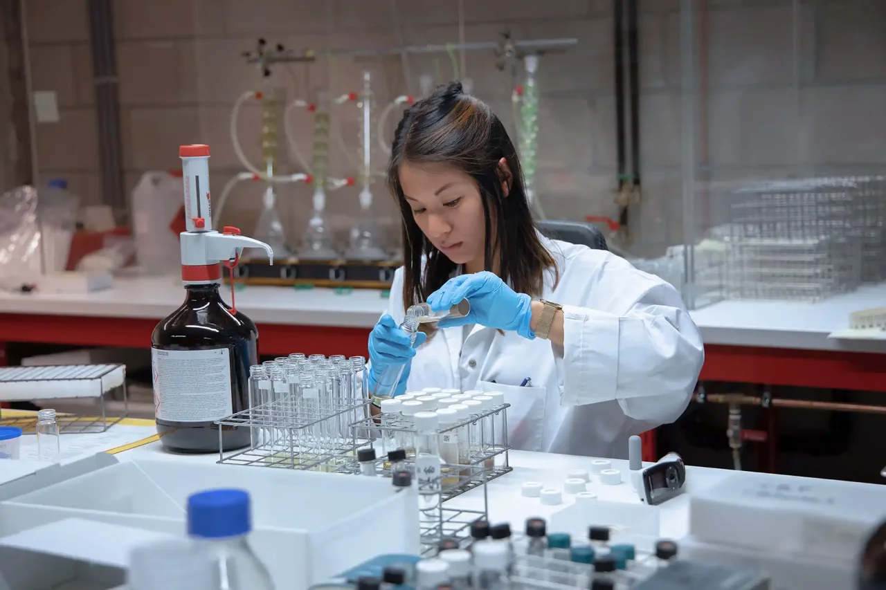 Woman tests liquid in Normec Servaco laboratory.