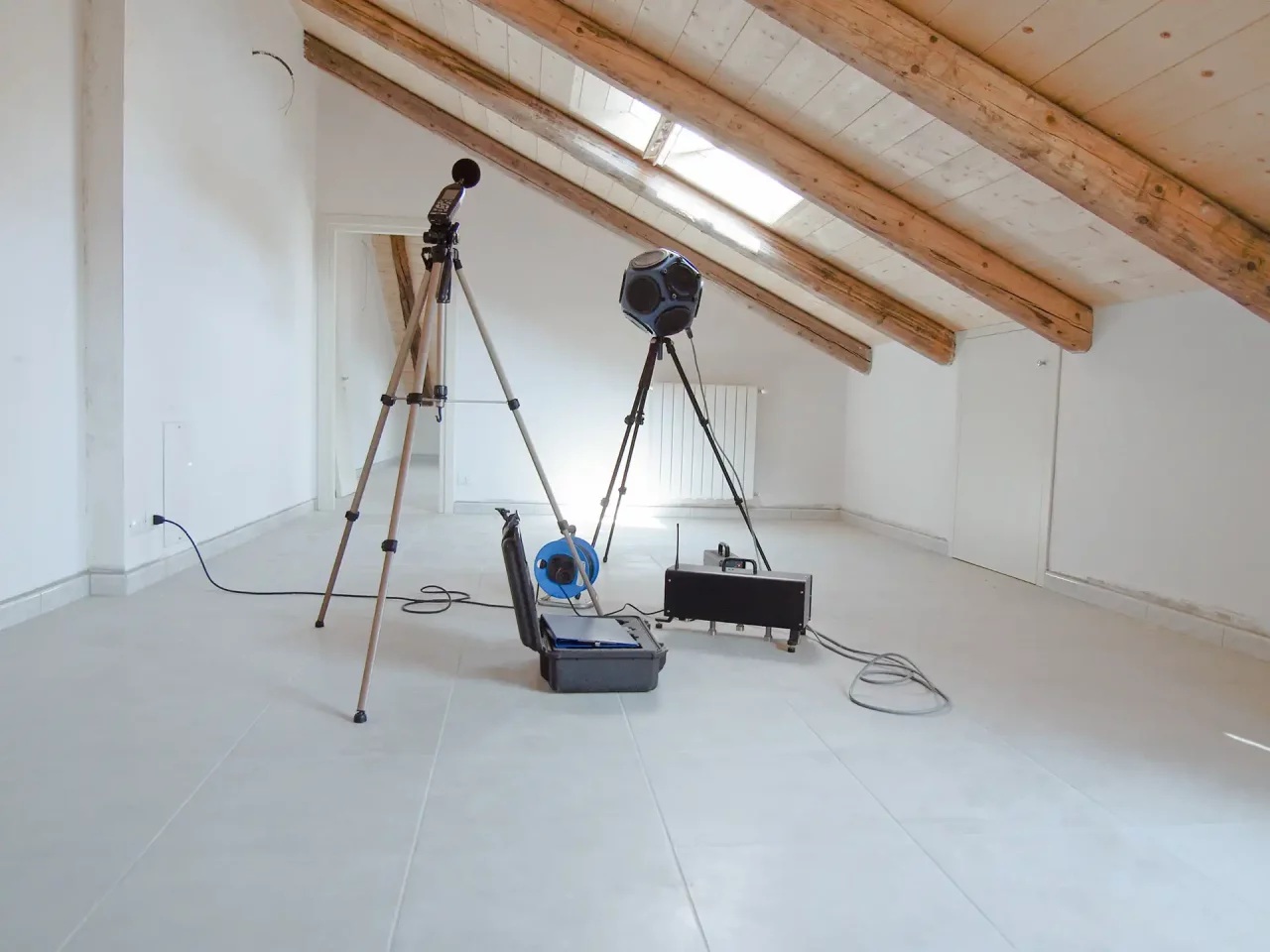 Measuring equipment and lighting in attic for examination by Normec Uppenkamp.